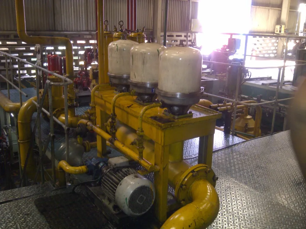 Three centrifuge filters on a yellow skid installed in an industrial plant for quenching oil cleaning
